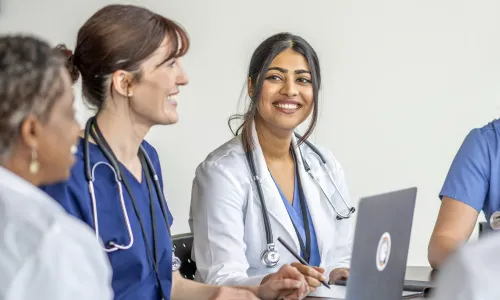 Nurse Practitioner Who Went From RN to MSN Online Smiling with Patient