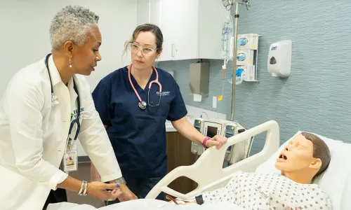 Accelerated BSN student in Atlanta with teacher in simulation lab