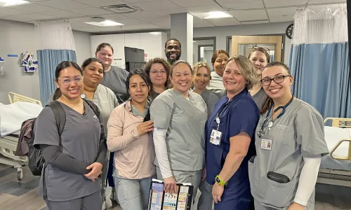 Group of Herzing Clarksville nursing students in scrubs posing for photograph during labs