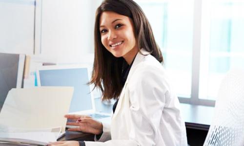 Medical Billing and Coding Specialist Smiling at Desk 