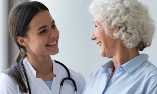 Primary Care Nurse Practitioner Smiling with Adult Female Patient 