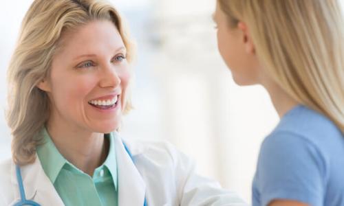 Family Nurse Practitioner with Post Master's Certificate Smiling at Young Patient 