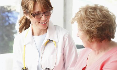Adult Primary Care Nurse Practitioner Smiling with Elderly Patient