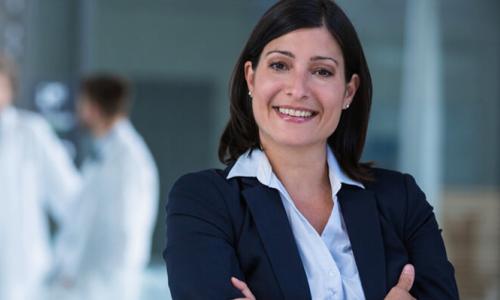 Nurse Leader with Healthcare Administrators in Meeting in Background 