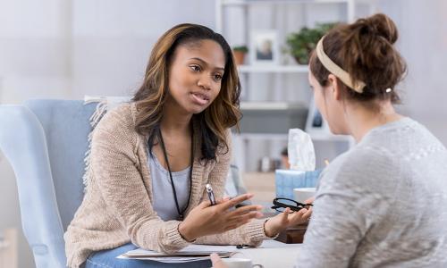 Substance Abuse Counselor with Psychology Degree Smiling with Client 