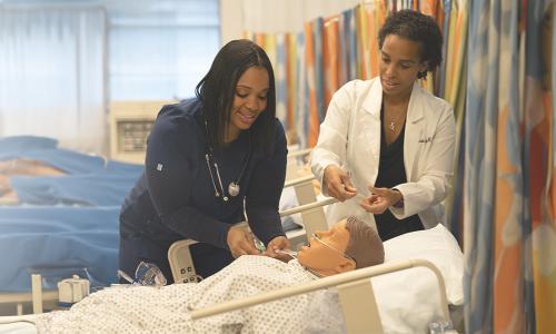 MSN Badge Banner NE Nurse Educator Herzing nurse educator teaching student in simulation