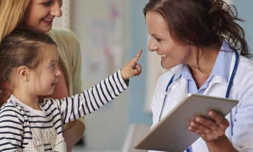 Pediatric Nurse Practitioner Smiling with Young Patient 