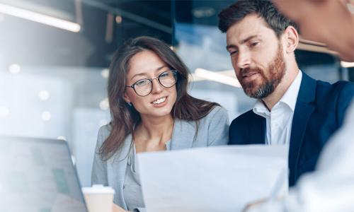 North Dakota business analyst reviewing reports with manager 