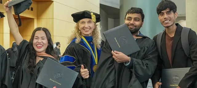 Herzing University international graduates celebrating together after the commencement ceremony.