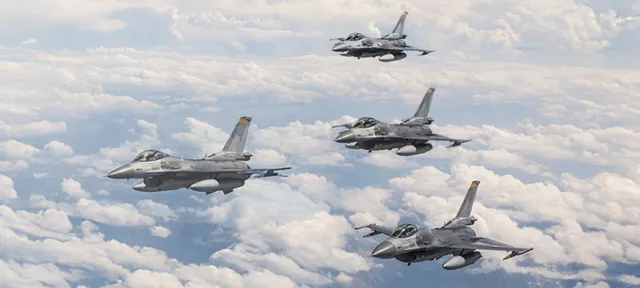 Us Air Force jets flying in formation with clouds in the background.