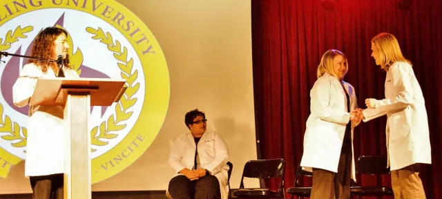 Herzing University Minneapolis white coat ceremony on stage