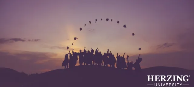 College graduates celebrating at sunset