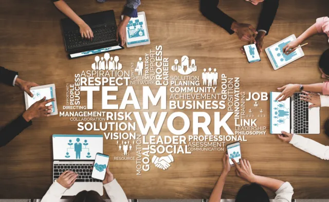 Word cloud of human resources-related words, such as teamwork, business, solution, respect, and more superimposed over a meeting between HR managers