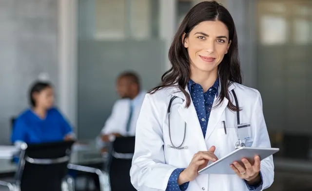 Nurse practitioner smiling in office after meeting with hospital administrators