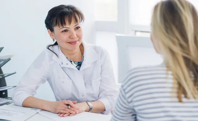 Adult Gerontology nurse practitioner smiling during appointment with patient