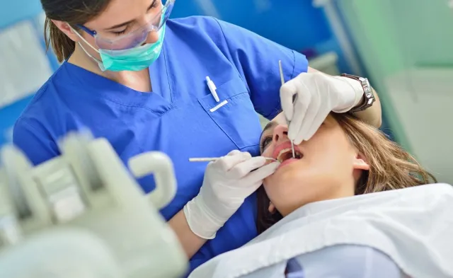 Dental Hygienist in Dentist Office Cleaning Teeth