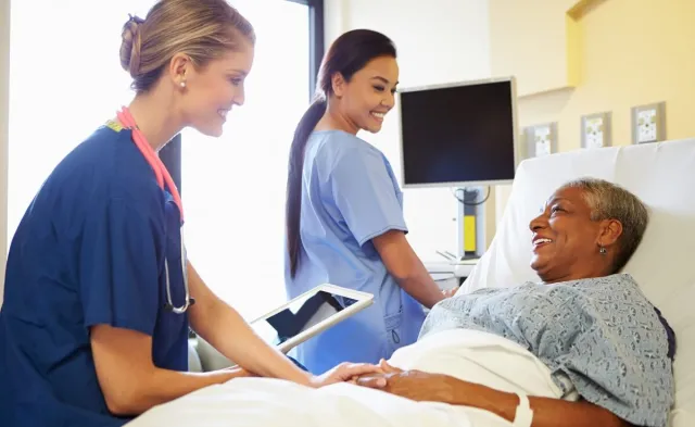 CVICU Cardiac Nurse Speaking with Patient in Hospital Bed