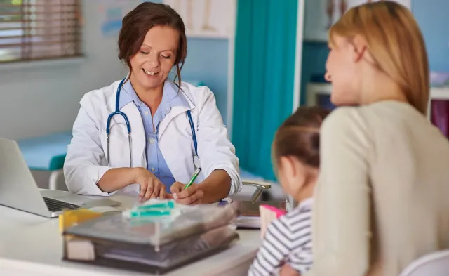 Pediatric Nurse Practitioner Smiling During Exam of Young Patient