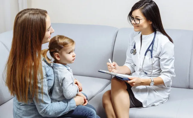 Pediatric Nurse Practitioner Smiling with Patient in Exam