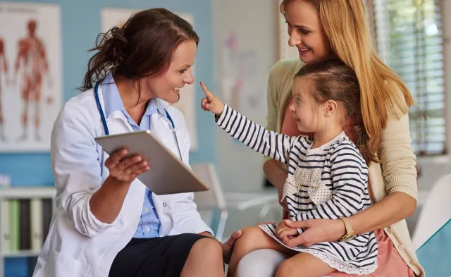 Pediatric Nurse Practitioner Smiling with Young Patient During Exam