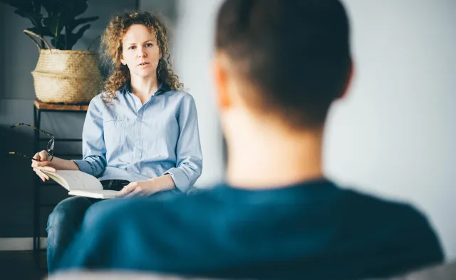 Psychiatric nurse practitioner speaking with client in an office environment