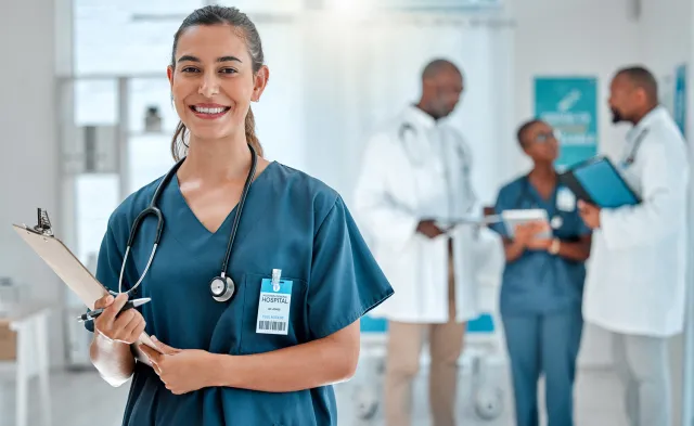 Nurse in Green Scrubs Smiling While Holding Clipboard