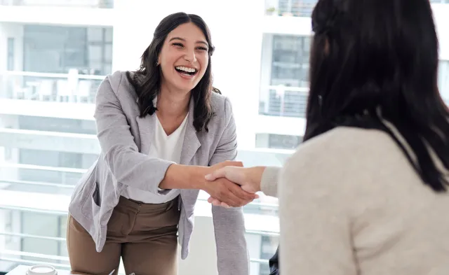Human Resources Manager Smiling and Shaking Hands with Coworker