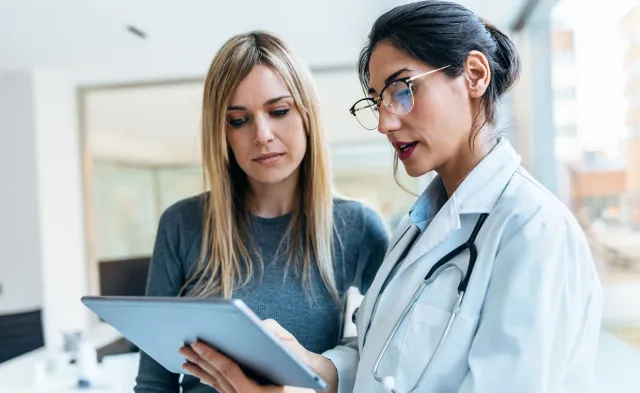 Women's health nurse practitioner reviewing test results with female patient