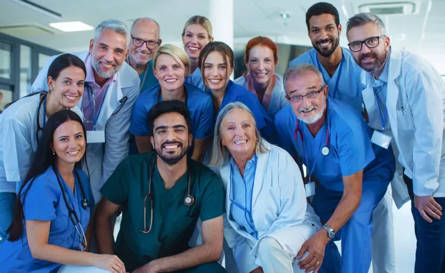 Team of healthcare professionals posing for group photo in hospital