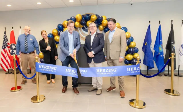 Erik Parks and other Herzing staff cutting a blue ribbon at Herzing Clarksville Grand Opening