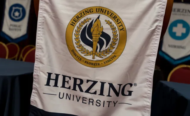 Herzing University banner at graduation