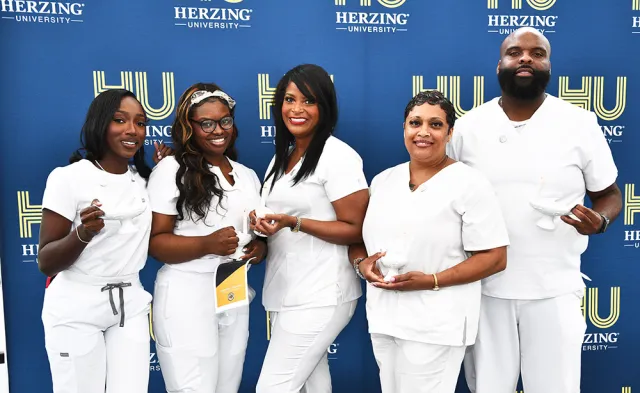 Herzing New Orleans nursing graduates smiling for photograph after commencement ceremony