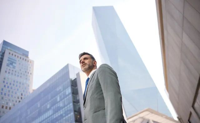 Man in a suit standing in the street.