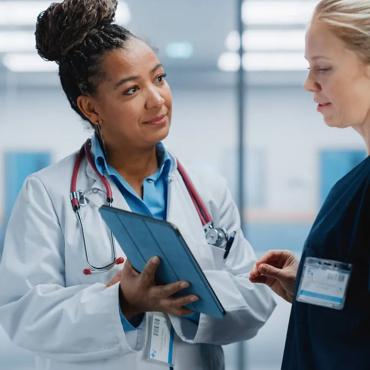 Nurse Practitioner Showing Patient Chart to Registered Nurse Public Health Nurses Discussing Patient Charts