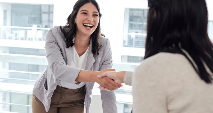 Human Resources Manager Shaking Hands and Smiling with Coworker