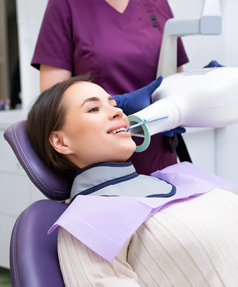 A dental professional using advanced radiology equipment to capture a dental X-ray, representing hands-on training in Herzing University’s dental radiology certificate program.