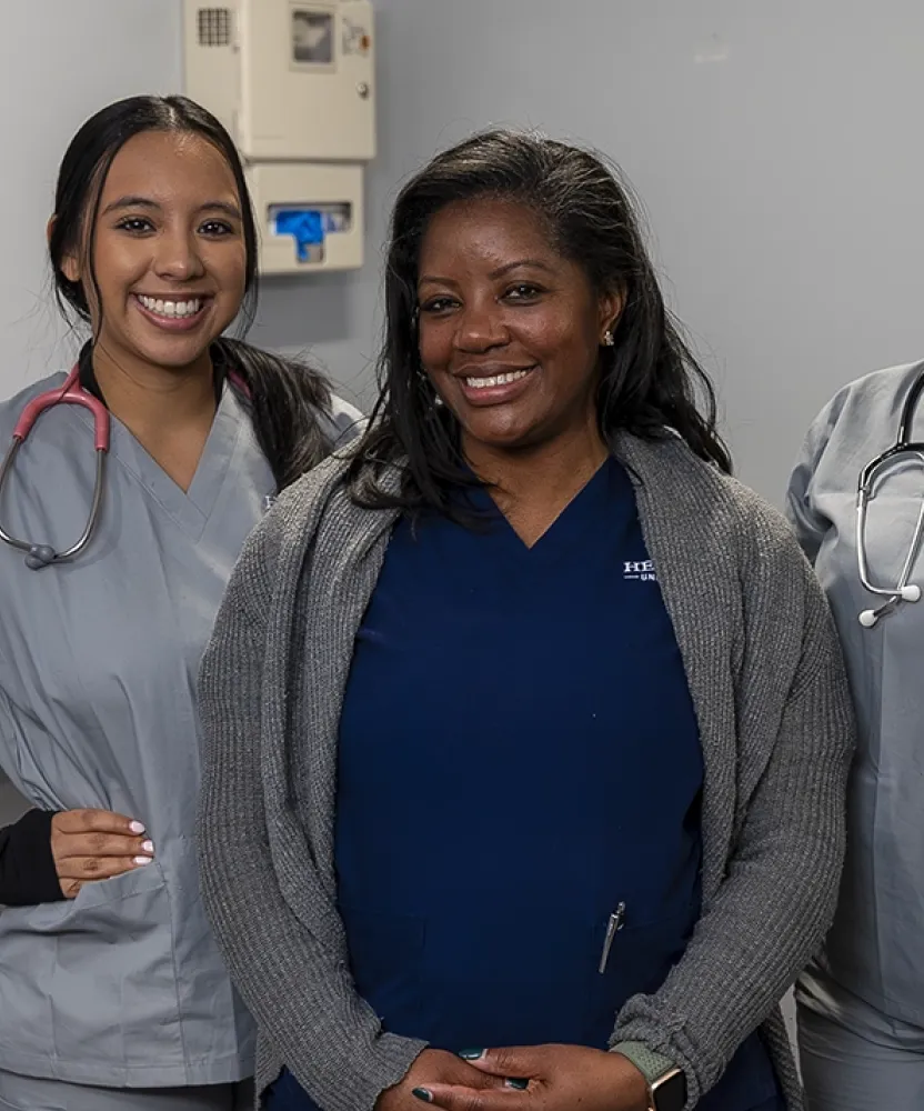 Herzing Birmingham nursing students smiling in scrubs during on campus laboratory experience