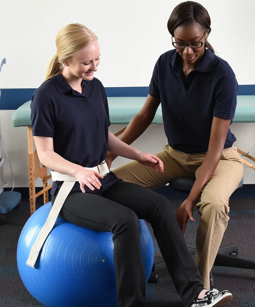 Physical therapist assistant helping patient to stretch