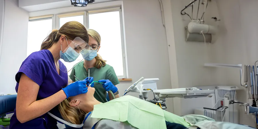 Dental hygienist students in Minneapolis school learning basic procedures on clinic customer