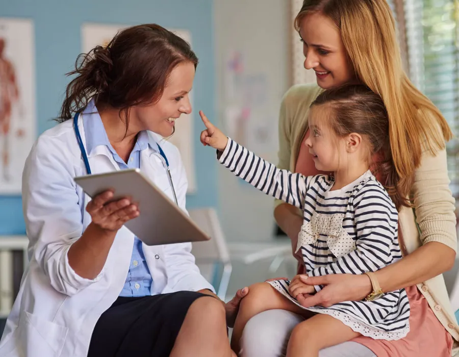 Pediatric Nurse Practitioner Smiling with Young Patient During Exam