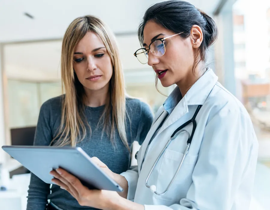 Women's health nurse practitioner reviewing test results with female patient