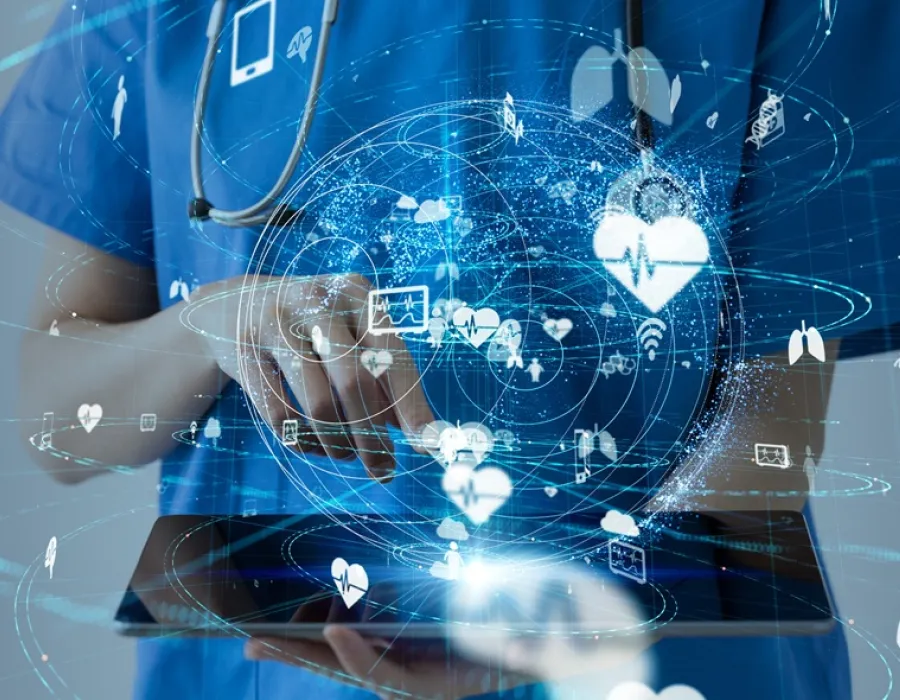 A nurse holding a tablet with multiple icons seen in front of her.