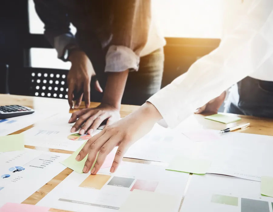Project manager and team members coordinating project with documents on desktop