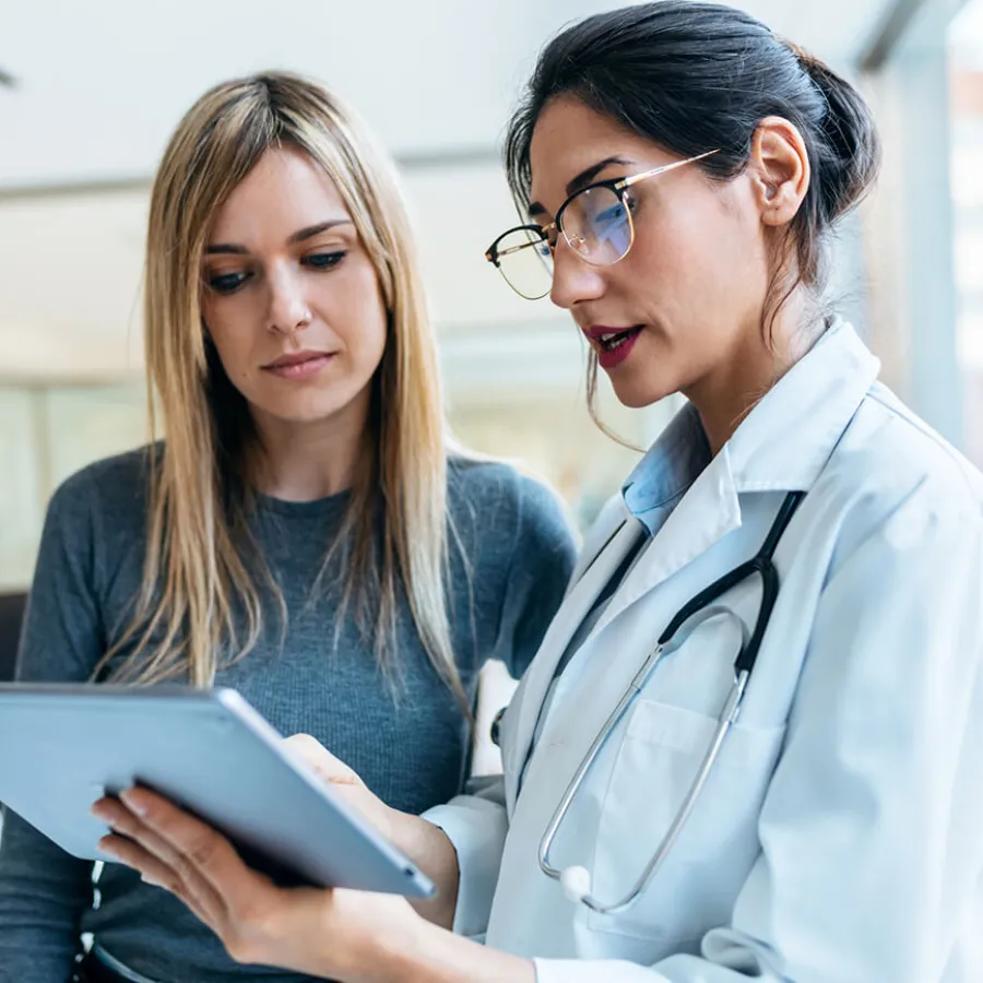 Women's health nurse practitioner reviewing test results with female patient