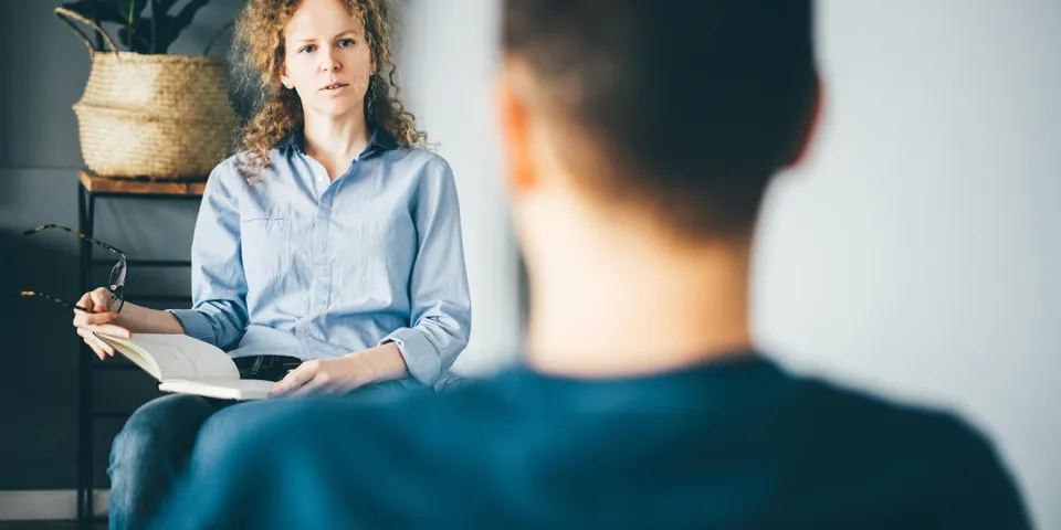 Psychiatric nurse practitioner speaking with client in an office environment