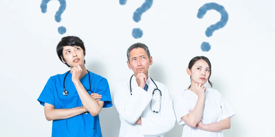 Three medical professionals deep in thought with question marks over their heads