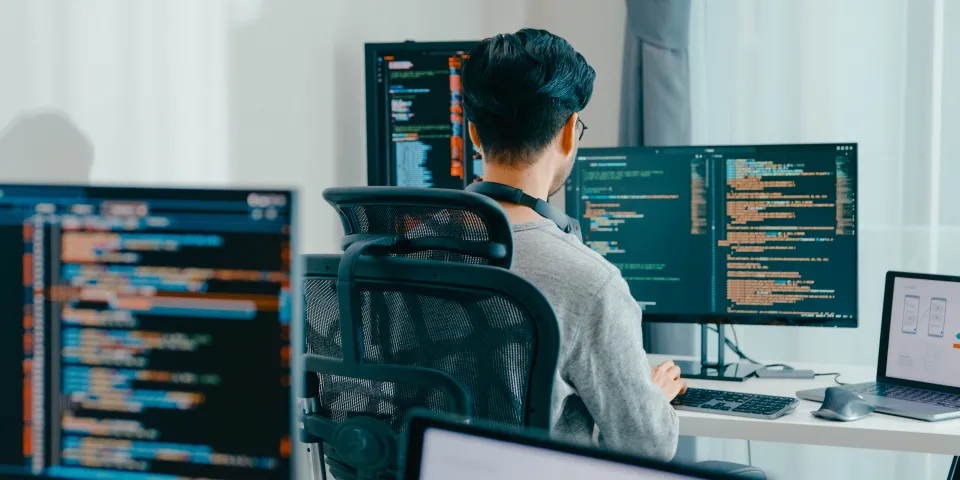 Young adult Asia male freelance eyeglasses typing write prompt AI bot IT app smart program nomad, video game, terminal with coding, user interface, designer, big data center on desktop computer.