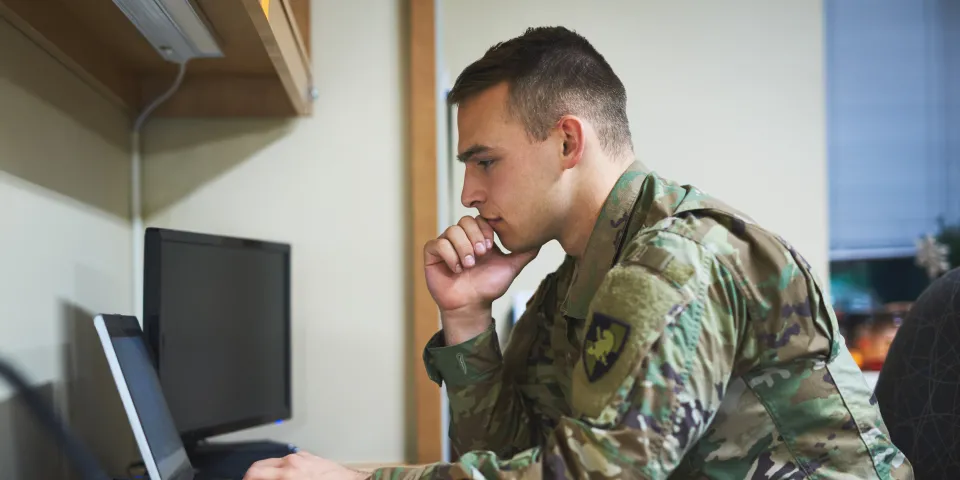 Shot of a young soldier using a laptop at a desk