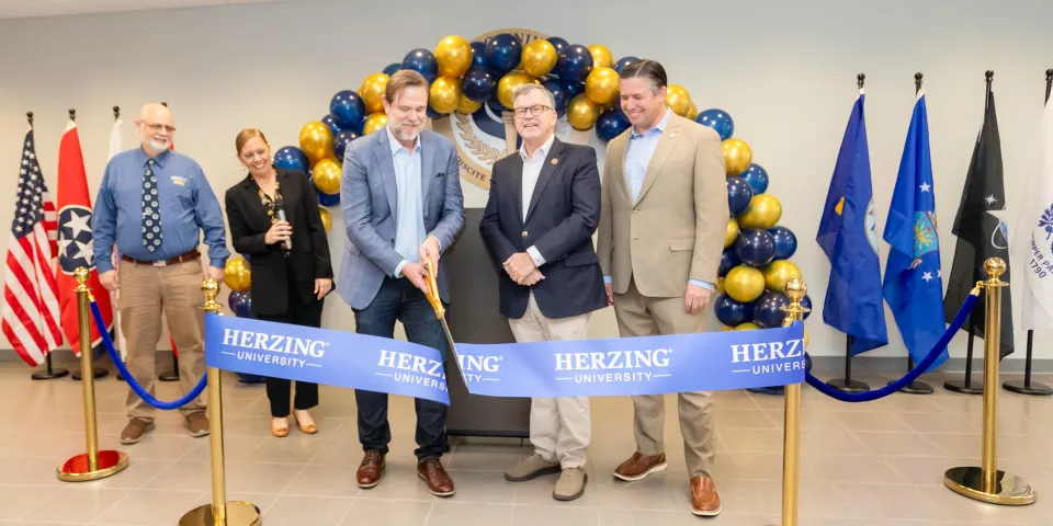 Erik Parks and other Herzing staff cutting a blue ribbon at Herzing Clarksville Grand Opening