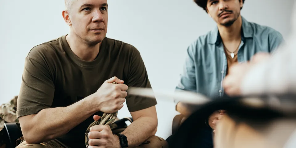 Military officer listening to therapist while having group therapy meeting at community center.